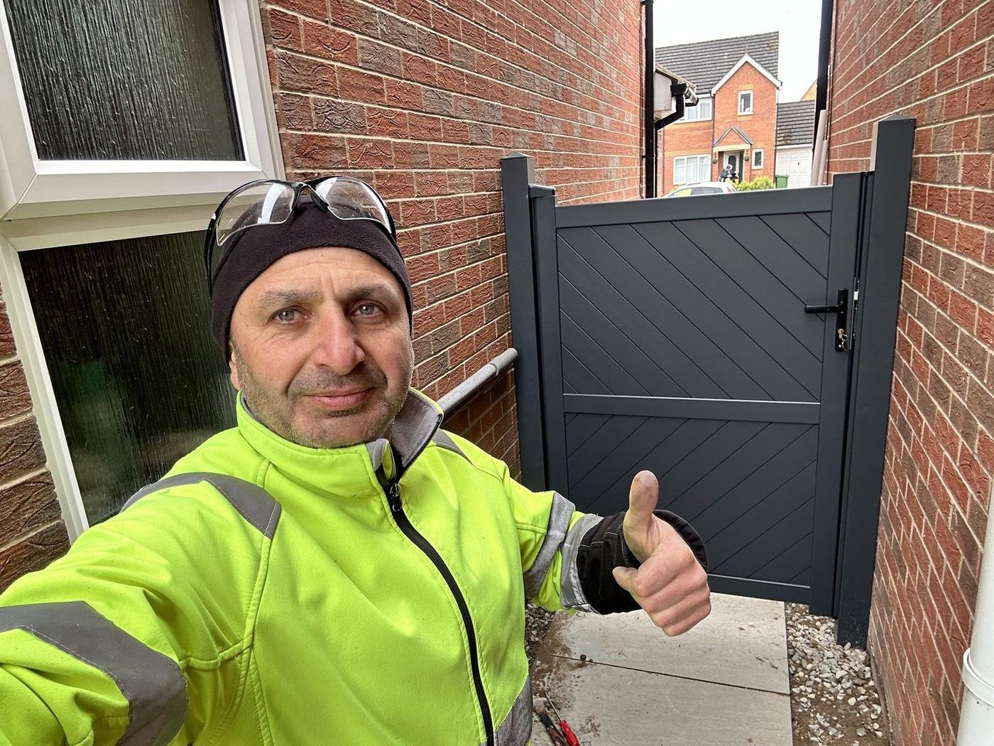 Norman in a hi-vis jacket giving a thumbs up beside a new grey gate